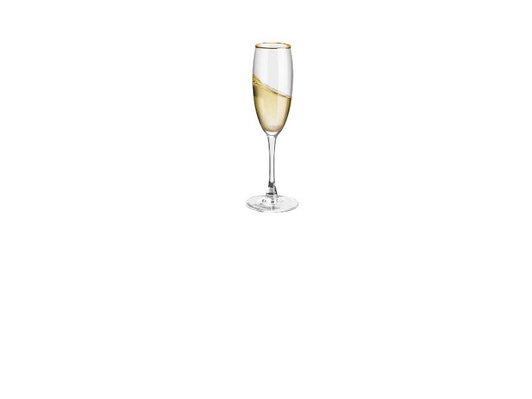 Ein Champagnerglas mit goldfarbenem Rand, gefüllt mit Champagner.