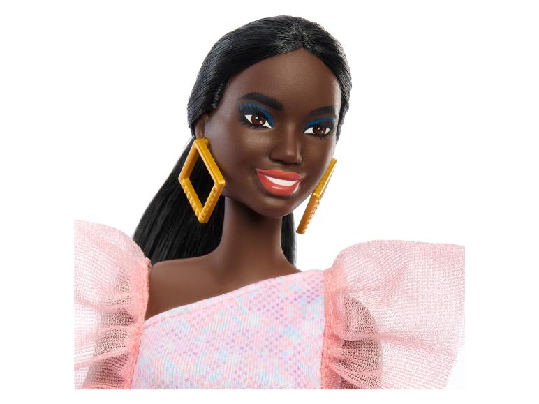 Barbie-Puppe mit einem rosafarbenen Kleid mit Rüschen und goldenen Ohrringen.