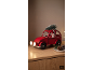 Rotes Weihnachtsauto mit Tannenbaum und Weihnachtsmann auf einem Holztisch.
