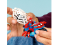 Hände halten ein rot-blaues Spielzeugmotorrad mit Superheldenfigur und weißem Netz.