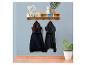 Holzgarderobe mit Ablage, Schubladen und Haken, mit zwei Jacken, Dekoration und Pflanzen.