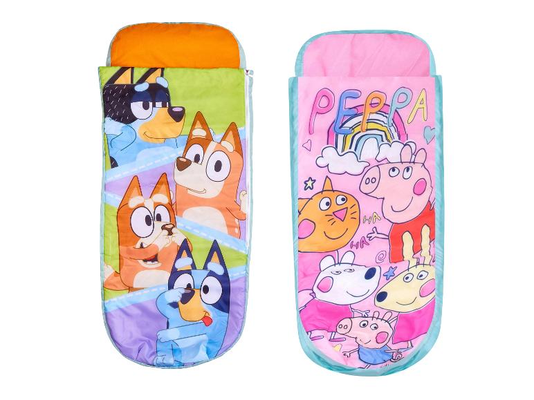 Zwei Kinderschlafsäcke, einer mit Zeichentrickhunden und der andere mit Zeichentrickschweinen.