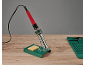 Lötkolben mit Ständer und Schwamm, sowie Silikonmatte auf einem Holztisch.