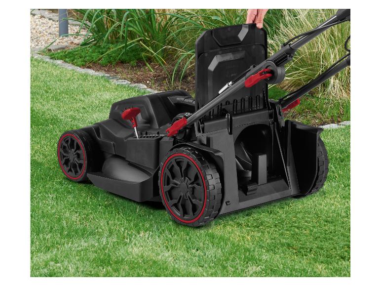 Akku-Rasenmäher mit roten Akzenten auf grünem Gras, eine Hand öffnet die obere Abdeckung.