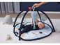 Ein Baby liegt auf einer Spielmatte mit einem Tintenfisch-, Wal- und Fischmotiv.