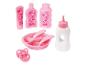 Eine rosa Babyflasche, ein Teller mit Besteck, ein Schnuller und zwei Flaschen mit Vogelmotiv.
