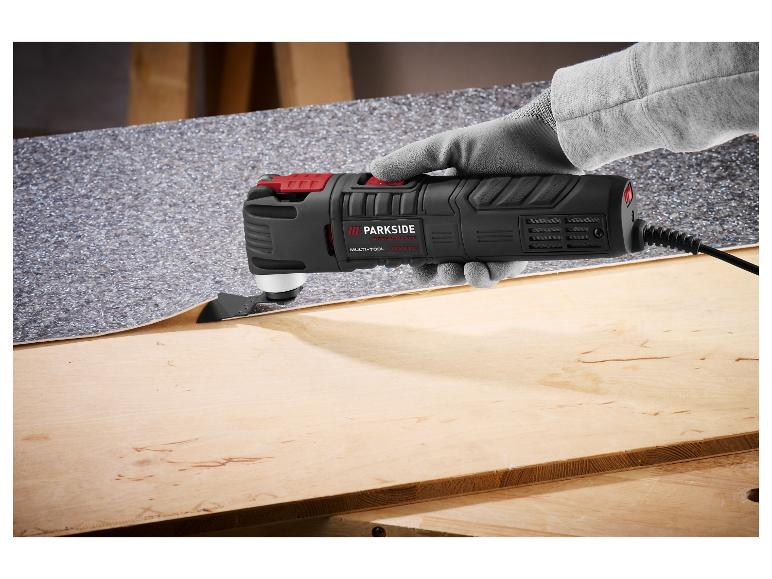 Multifunktionswerkzeug mit Klinge schneidet Bodenbelag auf Holzoberfläche.