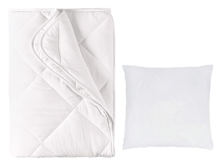 Weiße gesteppte Bettdecke und Kissen