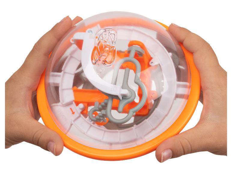 Zwei Hände halten ein orangefarbenes und transparentes Kugel-Labyrinth.