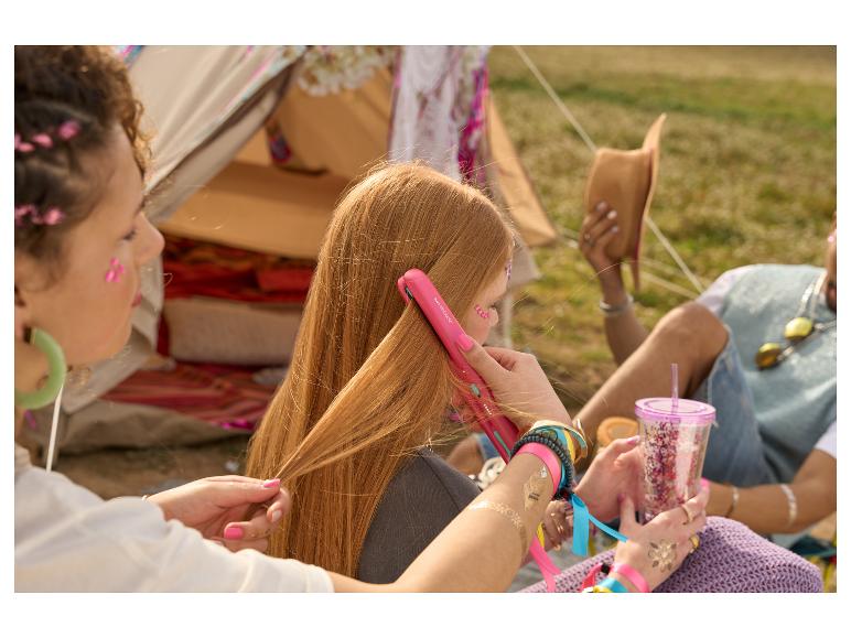 Haar glätten mit einem rosa SilverCrest Glätteisen, Sommerfestival.