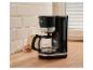 Schwarze Kaffeemaschine mit Kanne auf Holzarbeitsplatte, daneben Milch und Kekse.