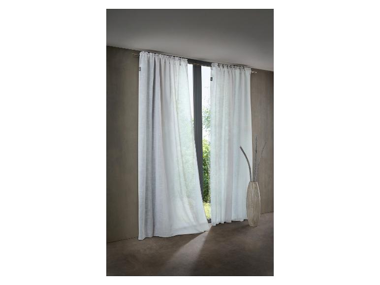 Weiße transparente Vorhänge an einer Stange, mit einer dekorativen Vase und Ästen auf dem Boden.