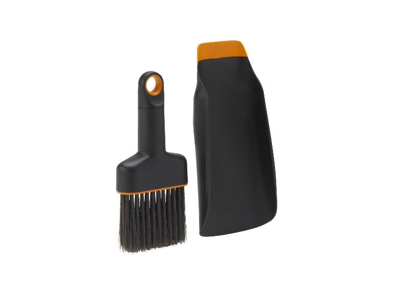 Reinigungsset mit schwarzer Bürste und orangefarbener Kehrschaufel.