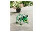 Ein grüner Frosch mit Blumenmuster, einer Solarleuchte und einem Topf mit rosa Blumen.