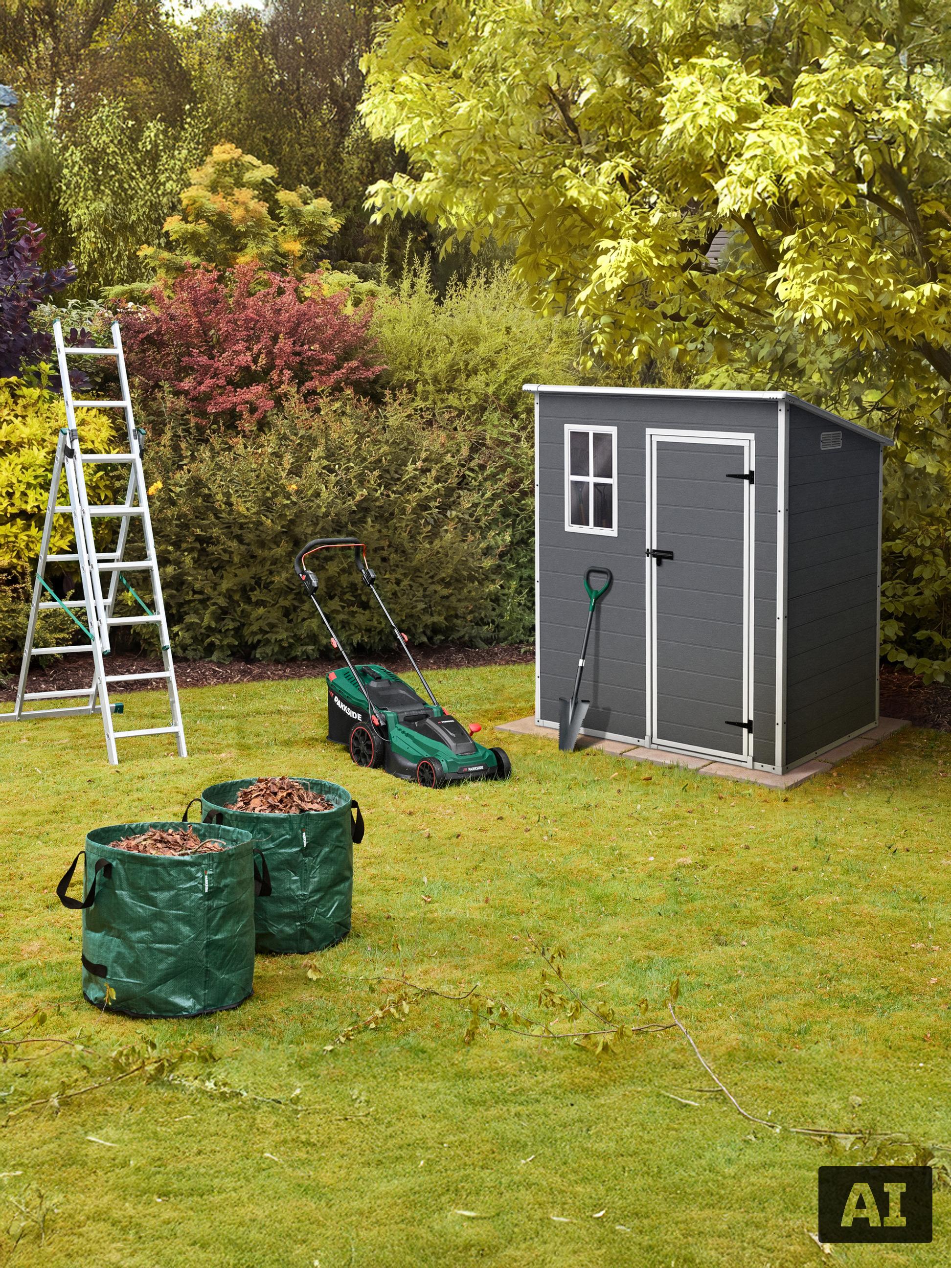 Ein Rasenmäher, eine Leiter, ein Gartenhaus und zwei Laubsäcke auf einem Rasen.