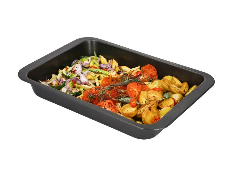 Geröstetes Gemüse und Kartoffeln mit Kräutern und Gewürzen in einer schwarzen Auflaufform.
