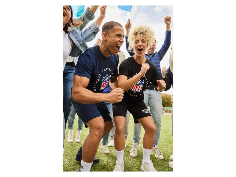 Begeisterte Fans in NFL-Kleidung jubeln auf einem Footballfeld.