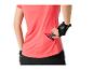 Frau in pinkem Fitness-T-Shirt und Handschuhen, die einen Energieriegel in eine Tasche steckt.