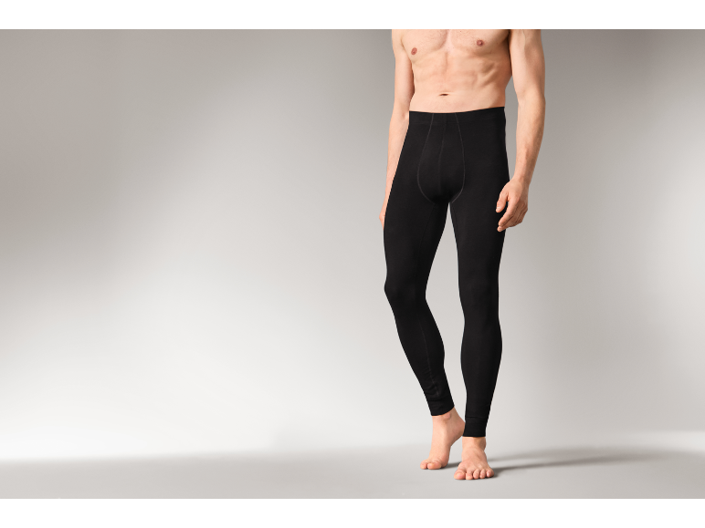 Ein Mann in schwarzen Thermo-Leggings vor grauem Hintergrund.