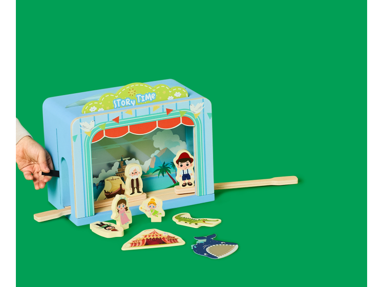 Puppentheater aus Holz mit Märchenfiguren auf grünem Hintergrund