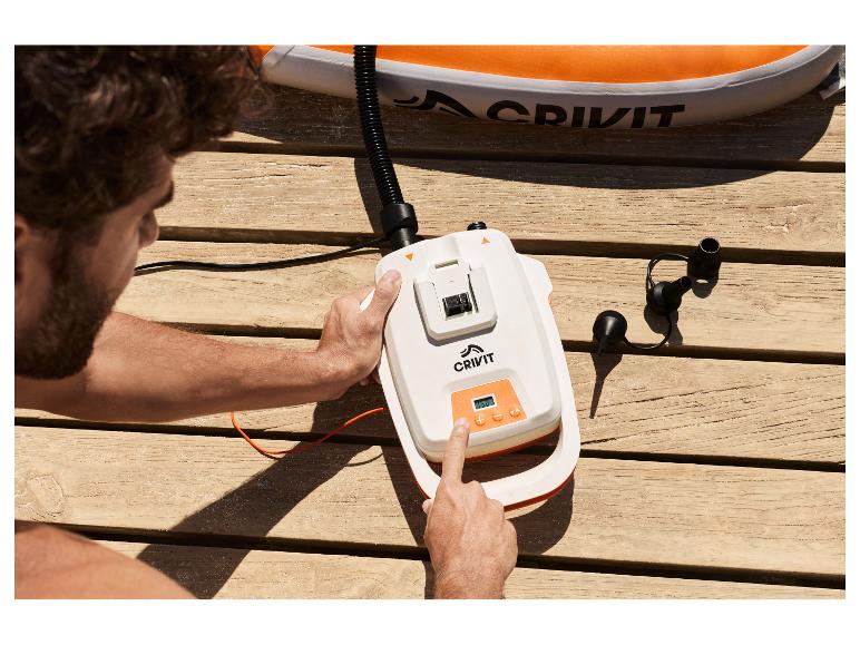 Mann pumpt ein CRIVIT SUP-Board mit einer 20 V Pumpe auf einem Holzsteg auf.