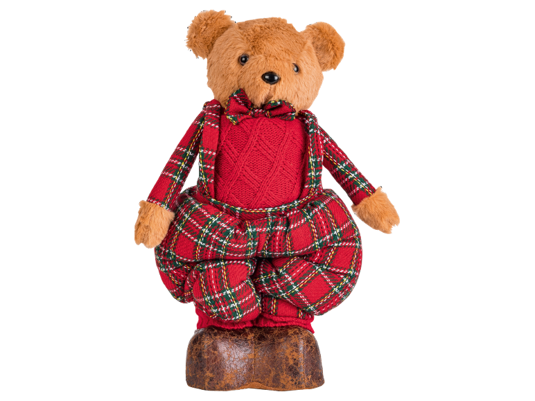 Teddybär in rotem Pullover und kariertem Overall, stehend auf einem Ledersockel.