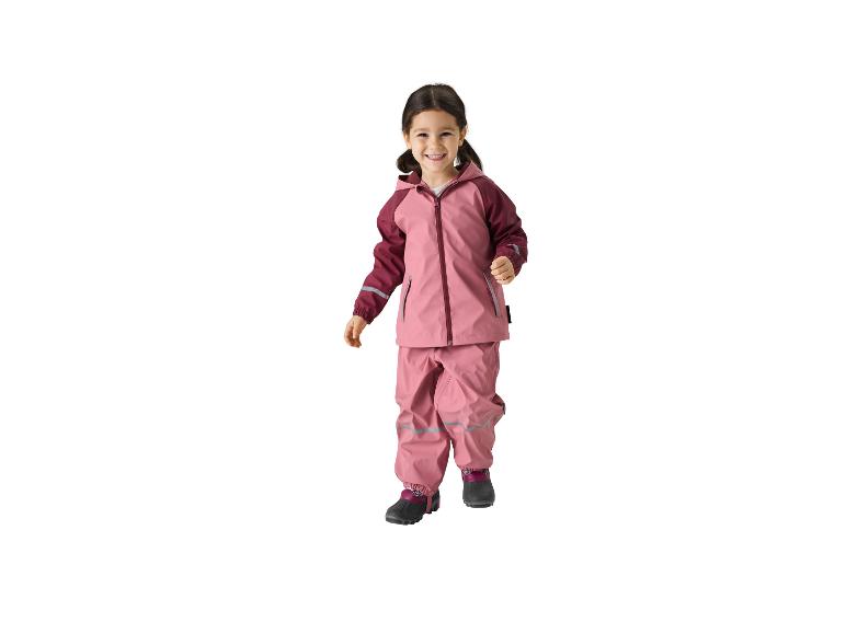 Lächelndes Mädchen in rosa Regenjacke und -hose.