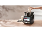 Küchenmaschine mit Touchscreen, Mehl, Milch und Eiern auf einem Holztisch.