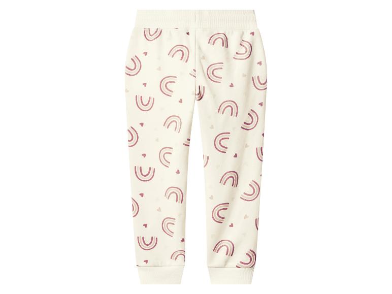 Cremefarbene Kinder-Jogginghose mit rosa Regenbogen- und Herzmustern.