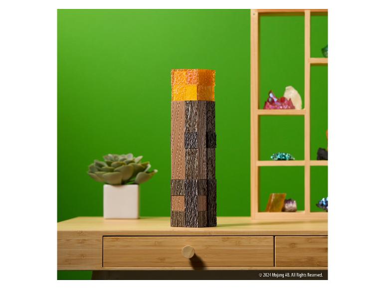 The Noble Collection Minecraft Fackel-Lampe auf einem Schreibtisch aus Holz vor grünem Hintergrund