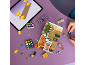 Blick von oben auf eine Person, die einen Spielzeug-Blumenladen mit einer Anleitung auf einem Tablet baut.