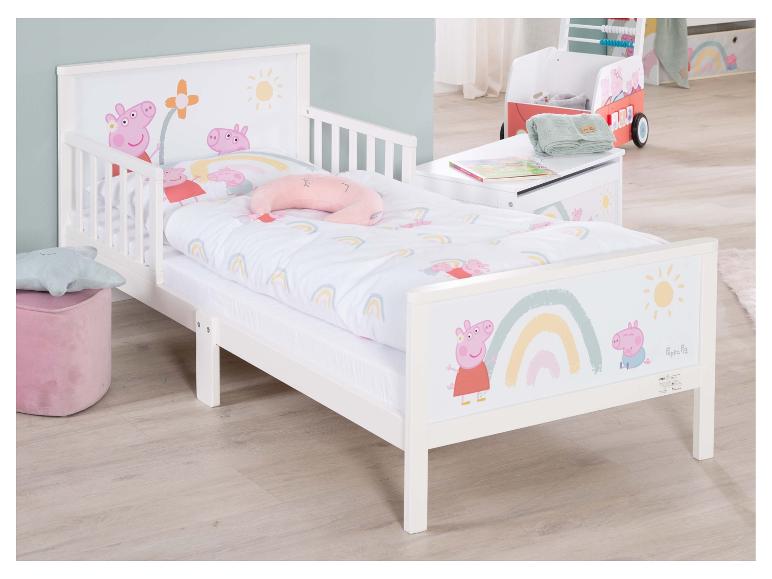 Weißes Kinderbett mit Schwein-, Regenbogen- und Sonnenmotiv, mit rosa Pouf und Spielzeugwagen.