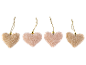 Vier dekorative Filzherzen, zwei rosa und zwei beige, mit goldenen Kordeln.
