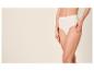 Frau in beigem Slip mit hoher Taille, eine Hand auf dem Oberschenkel.