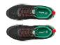 Paar schwarze und grüne Sneaker mit roten Schnürsenkeln, mit '30 YEARS EST. 1996' auf der Zunge.