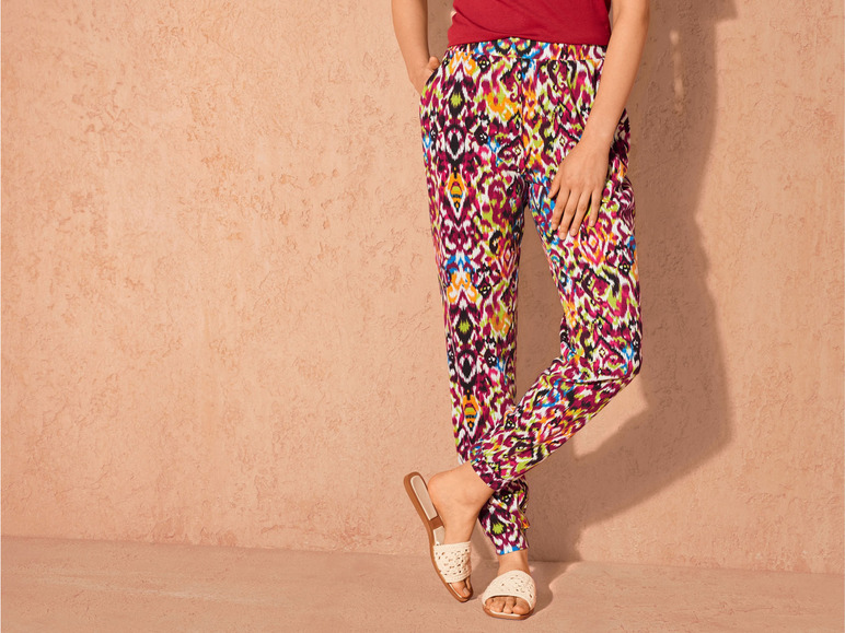 Damenhose mit farbenfrohem Muster und weißen Sandalen.