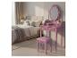 Rosa Schminktisch mit Spiegel und Hocker in einem Schlafzimmer.