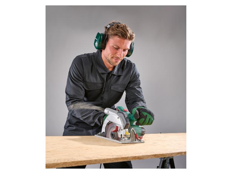 Mann in Arbeitskleidung und Gehörschutz sägt Holz mit einer Parkside Kreissäge.