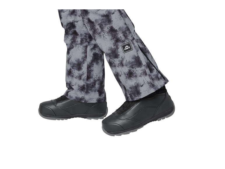 Graue gemusterte Hose und schwarze Schuhe.