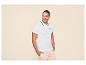 Mann in weißem Poloshirt mit schwarzem Besatz und hellbeigen Cargoshorts.