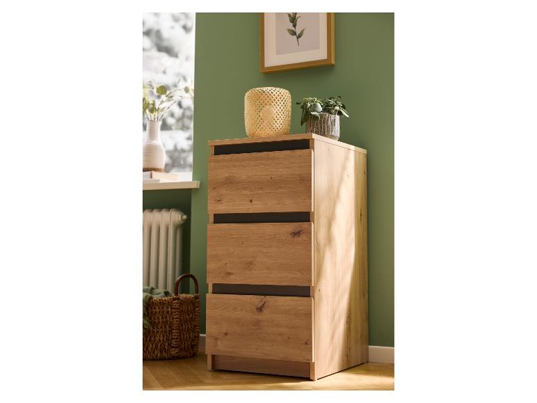 Holzkommode mit drei Schubladen in einem Raum mit grüner Wand und Dekoration.