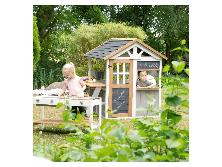 Zwei Kinder spielen mit einer Holzküche und einem Spielhaus im Freien.