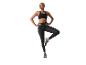 Frau in schwarzem Sport-BH und Leggings, balanciert auf einem Bein.