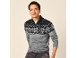 Mann in einem grau-schwarzen Fair Isle Pullover mit halbem Reißverschluss und dunklen Jeans.