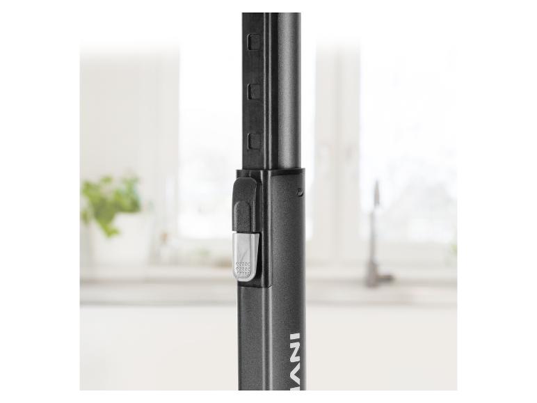 Nahaufnahme einer schwarzen Teleskopstange mit Verstellmechanismus in einem hellen Raum.