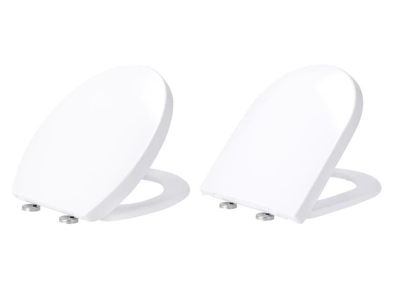 Zwei weiße, ovale Toilettensitze auf weißem Hintergrund