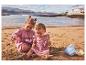 Zwei Kinder spielen am Strand mit Sandspielzeug, darunter ein Eimer und eine Schaufel.