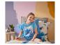Mädchen in Stitch-Pyjama und Bettwäsche, mit einem Stitch-Plüschtier.