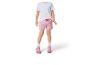 Mädchen in weißem T-Shirt und pinken gemusterten Shorts.
