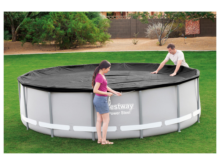 Zwei Personen decken einen Bestway Power Steel Pool mit einer schwarzen Abdeckung ab.